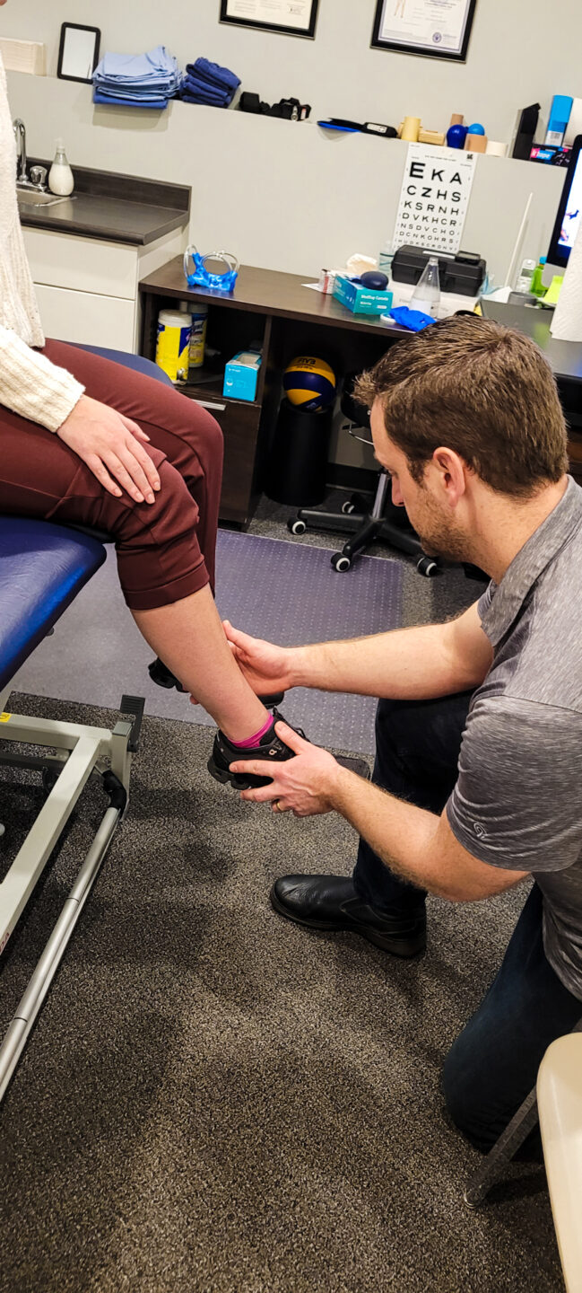Pete Assessing Shin A Physiotherapist holding a clients lower leg in hand assessing for shin splints